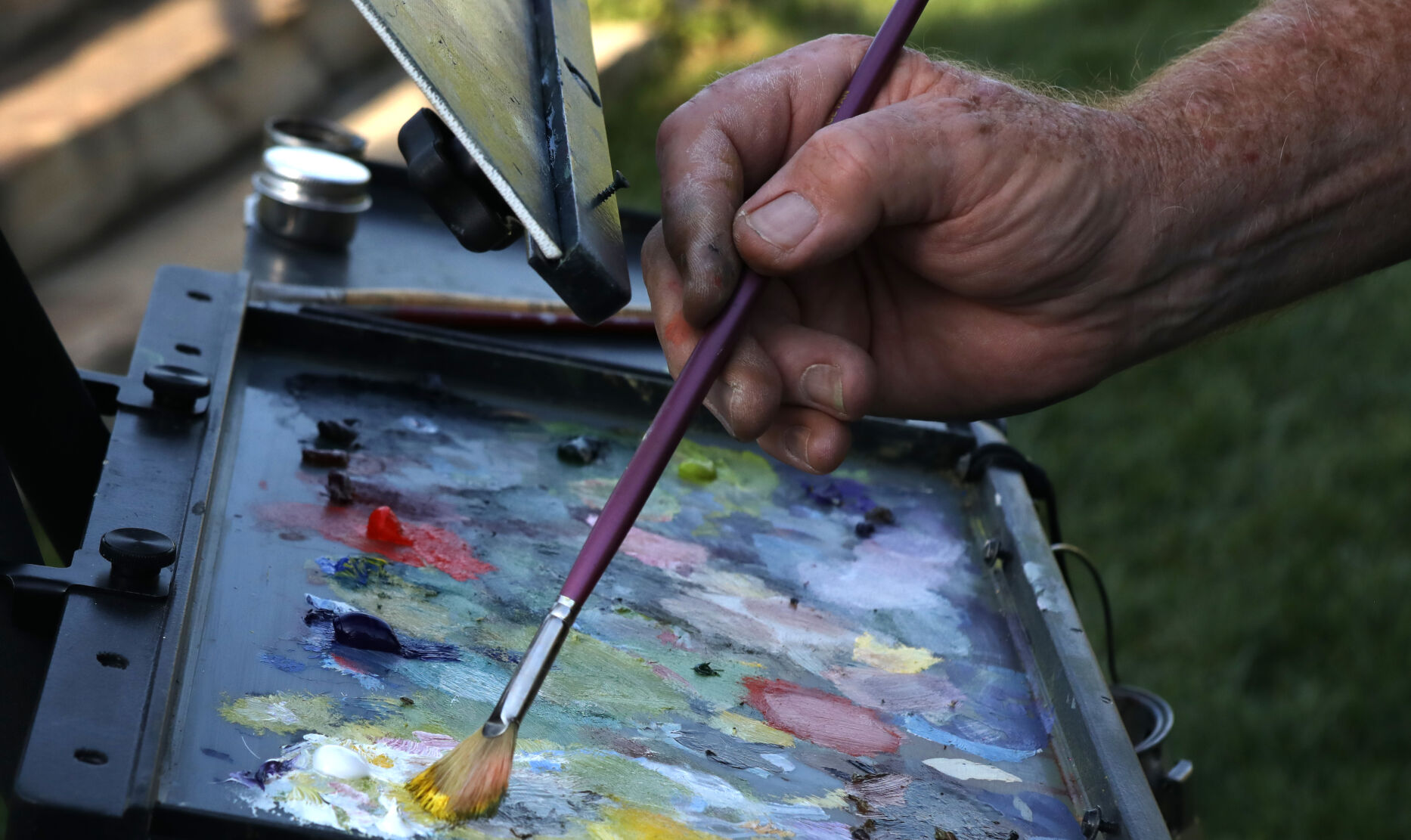 Mike Phelps dips his brush in oil paint